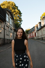 Frontal view of happy young woman walking down the street in Helsinki, Finland