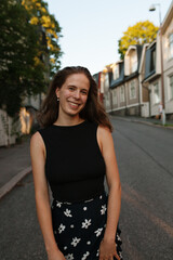 Smiling young woman standing on a calm neighbourhood road in Helsinki, Finland
