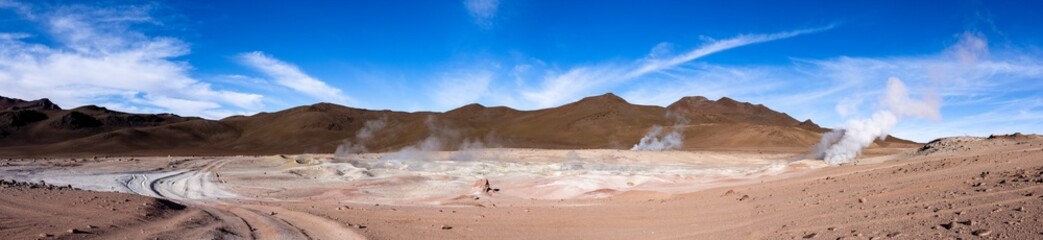 Fototapeta na wymiar Stunning geothermic field of Sol de Mañana with its steaming geysers and hot pools with bubbling mud - just one sight on the lagoon route in Bolivia, South America - Panorama