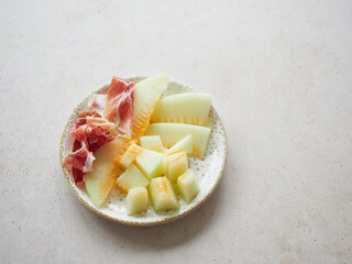 Melon with ham on a plate. Typical spanish tapa. Contrast sweet salty flavor.