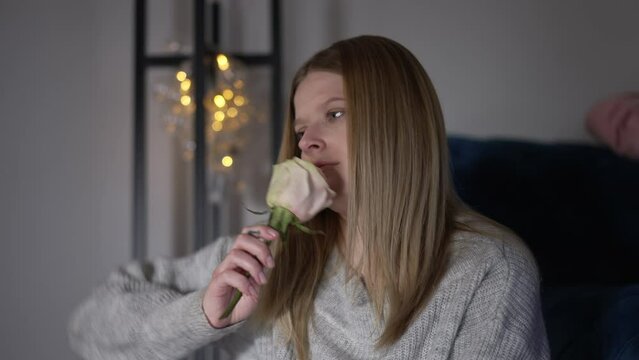 Young woman smelling rose throwing away flower in slow motion. Side angle view portrait of desperate furious Caucasian lady at home indoors after huge fight
