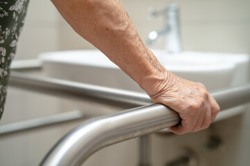 Asian elderly woman patient use toilet bathroom handle security in nursing hospital, healthy strong medical concept.