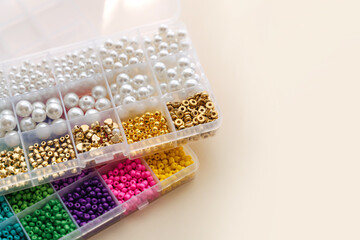 Boxes with multi-colored  beads and pearls beaded for children's needlework and crafts.  Handmade and DIY art activity for kids. Motor skills and creativity, hobby