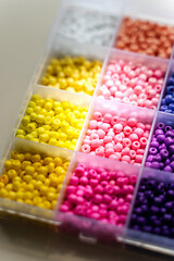 Box with multi-colored beads for children's needlework and crafts.  Handmade and DIY art activity for kids. Motor skills and creativity, hobby