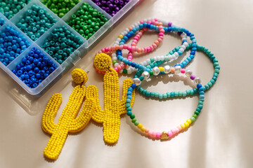Set of for needlework and beading. Kids handmade beaded jewelry and different multi-colored beads for children's crafts in boxes. DIY art activity for kids. Motor skills, creativity and  hobby.