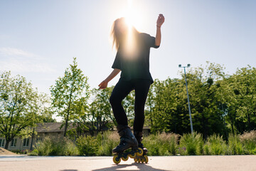 sporty girl rides roller skates in park on city background Active girl in enjoys roller skating...