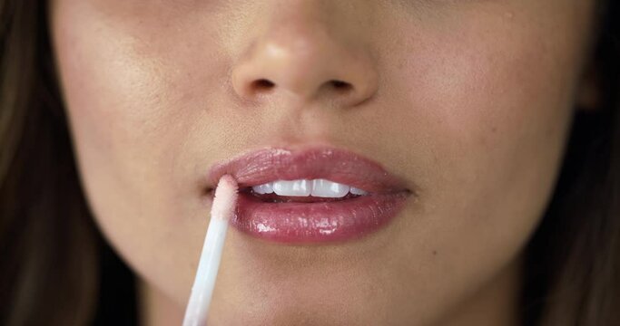 Woman, lip gloss makeup and mouth lipstick closeup of cosmetics and skincare. Female person, face and pout with natural beauty product with self care and model with lips cosmetic and applicator