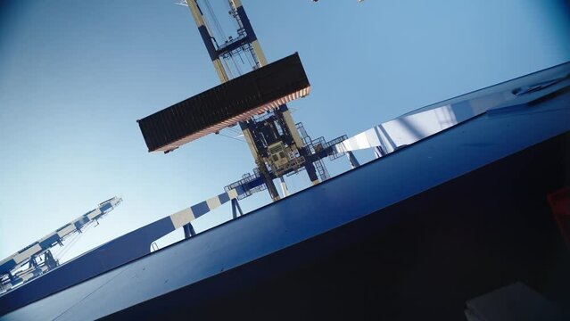 4K footage from right underneath port crane stock video. Crane lifting and placing cargo container stock video.