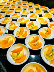 yellow pudding, or semifreddo, or mousse or panna cotta, garnished with apricot slices and pistachios. buffet. at catering event on some festive event, party or wedding reception