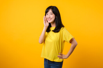 Portrait of a Young Asian Woman with Shout Hands Gesture Isolated on Yellow Studio Background