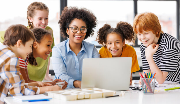 Teacher and students watching laptop screen.