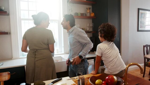 Working dad coming into the kitchen to have breakfast with his wife and son before going to work