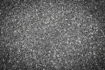 The road surface is strewn with dark gray small crushed granite pebbles. Used for a walkway or as a background image for graphic design work