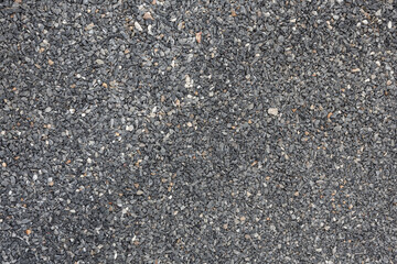 The road surface is strewn with dark gray small crushed granite pebbles. Used for a walkway or as a background image for graphic design work