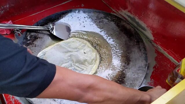 Cinematic shot. The making process of savory pan-fried pastry famously known as Martabak Telor stuffed with eggs, meat and onion leaf. One of the well known Indonesian Culinary cuisine