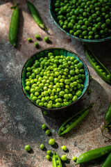 Bowl with fresh sweet peas on stone surface.