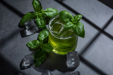 Green summer mint drink with ice and fresh basil hard light with shadows