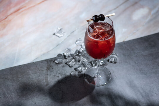 Summer cherry drink cocktail with ice and berries garnish
