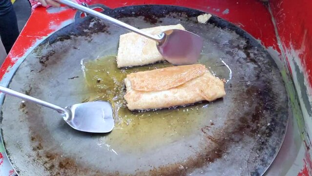 Cinematic shot. The making process of savory pan-fried pastry famously known as Martabak Telor stuffed with eggs, meat and onion leaf. One of the well known Indonesian Culinary cuisine