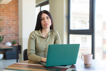 pretty young woman feeling sad and whiney with an unhappy look and crying. laptop and desk concept