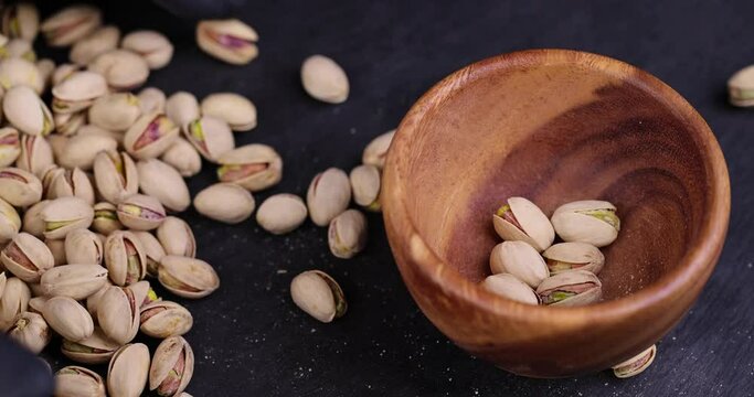 take salted pistachio nuts on the table, a large number of salty and crispy pistachios close-up