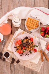 Waffles with strawberries and chocolate cream.