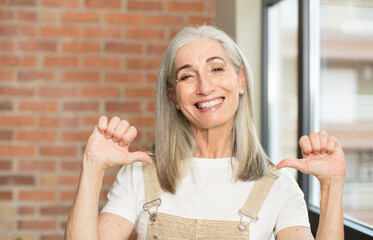 senior pretty woman feeling proud, arrogant and confident, looking satisfied and successful,...