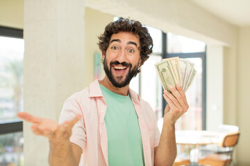 crazy bearded man smiling happily and offering or showing a concept. dollar banknotes concept