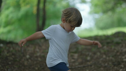 Child walking outside in nature little boy walks outdoors in green path