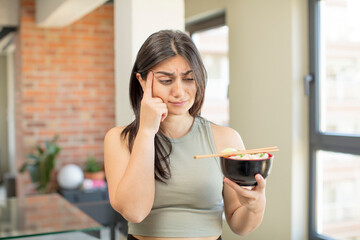 young woman looking surprised, realizing a new thought, idea or concept. ramen bowl