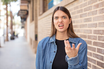 young pretty woman looking angry, annoyed and frustrated screaming wtf or what’s wrong with you
