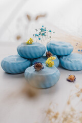 Handmade light blue soap with flowers on fabric, close-up