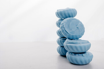 Fototapeta na wymiar Handmade light blue soap with flowers on fabric, close-up
