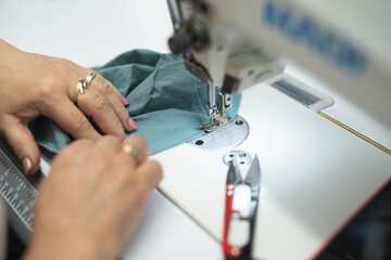workers in an industrial garment factory sew clothes on sewing machine