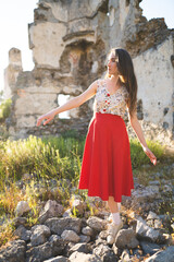 a beautiful girl in a red skirt among the ruins of the old town © Tsyb Oleh