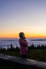 Fototapeta premium landscape in the mountains, sunset, sunrise, a girl looks at the horizon, conquering the peaks, tourist, hiking, silhouettes of peaks, Montenegrin mountain range, Carpathians, travel, screensaver
