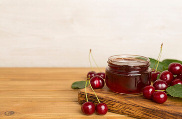 Jar with tasty homemade cherry jam on wooden table