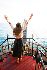 a beautiful girl in a pirate costume on the deck of a ship