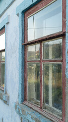 Old wooden window. The old wooden window is covered with red paint. Old wooden windows in a row. A wall with wooden windows