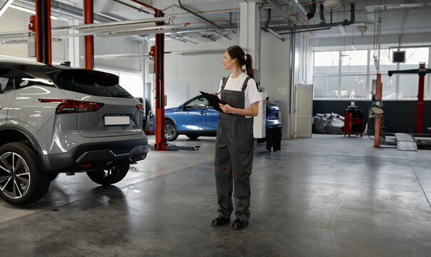 Young woman mechanic with clipboard at workshop
