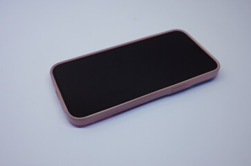 Focus on smartphone in pink case placed on white paper