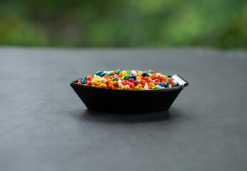 Colourful candies in black bowl