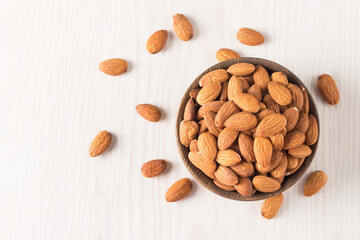 Raw peeled almonds in brown bowl
