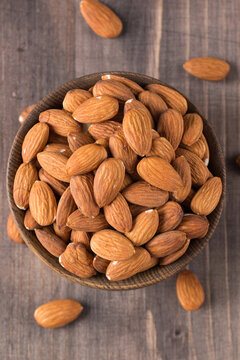 Raw peeled almonds in brown bowl