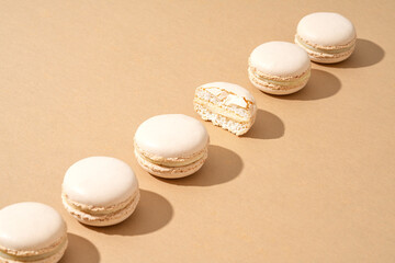 A still life image featuring six white macarons, arranged in a stack on top of each other