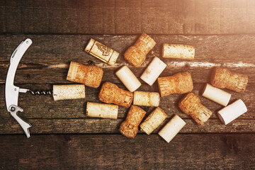 Corkscrew and vintage wine corks on wooden table
