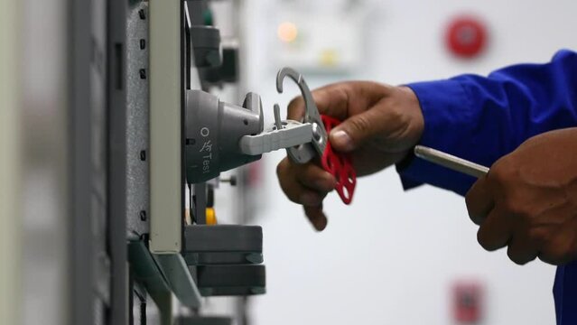 Locking and unlocking  LOTO of electric control cabinet keys before and after work for safety, industrial work and safety concept.