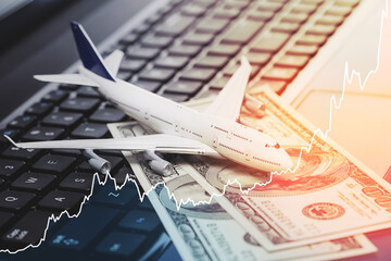 Toy aircraft, dollar bills and rising chart representing airfare rise