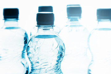 Blue bottles of pure still water against white background