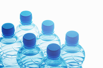 Blue bottles of pure still water against white background
